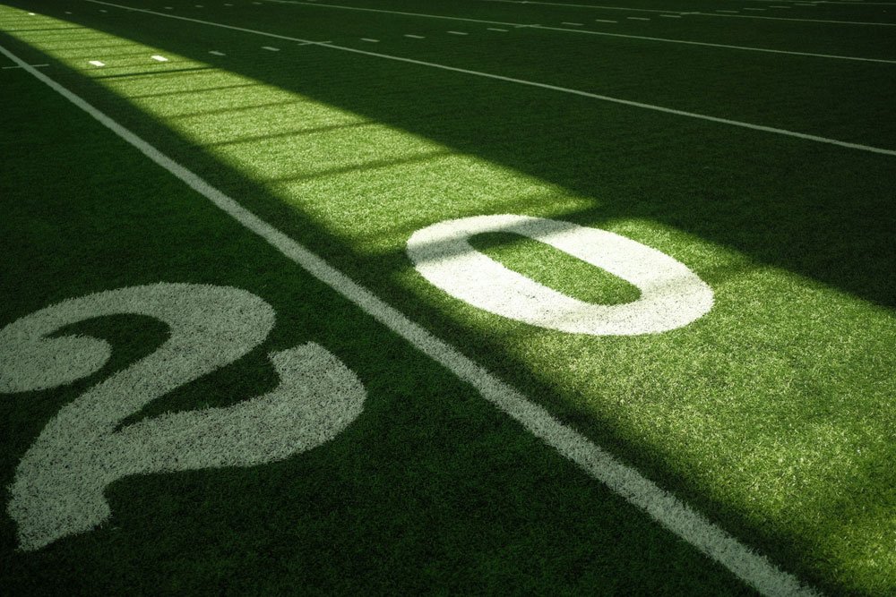 Football field yard lines with sunlight and shadows